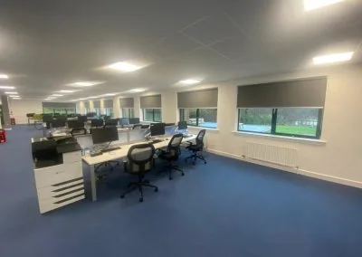 Commercial blind installation across open-plan office